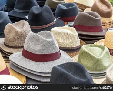 Many hats for men in different shapes and colors in one display for sale, germany