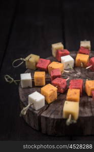 many kinds of cheeses on wooden end of a tree