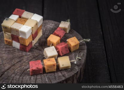 many kinds of cheeses on wooden end of a tree