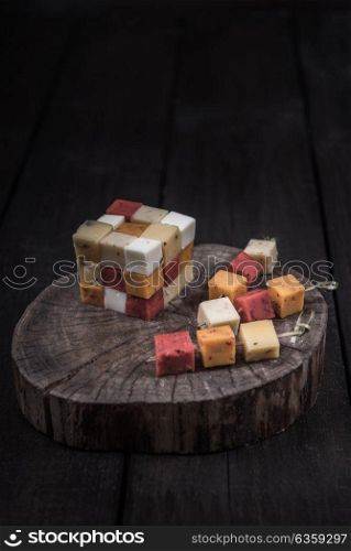 many kinds of cheeses on wooden end of a tree