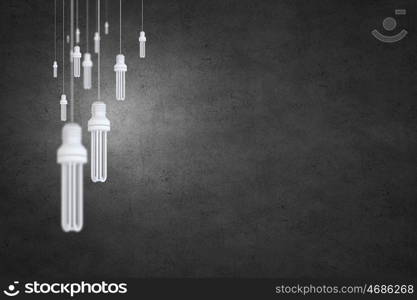 Many light bulbs on color background hanging from above. Hanging bulbs