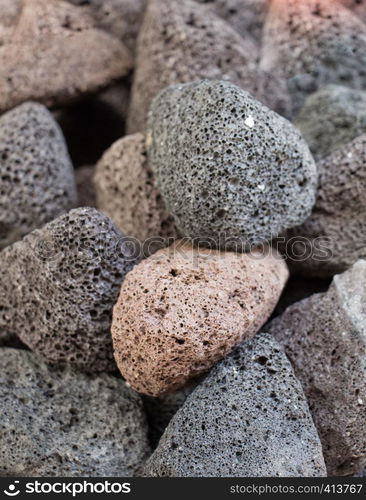 Many multicolored porous pumice stones in view