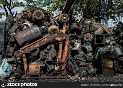 Many old rusty old car wheel axles, car shaft and used engines at the junk yard for sale. Focus and blur.