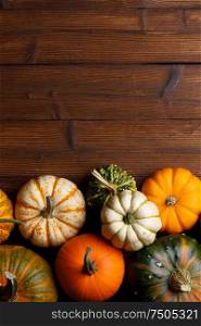 Many orange pumpkins on dark wooden background, Halloween concept, top view with copy space. Pumpkins on wooden background