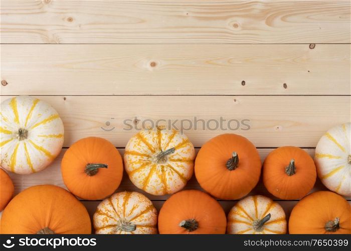 Many orange pumpkins on light wooden background , Halloween concept , top view with copy space. Pumpkins on wooden background