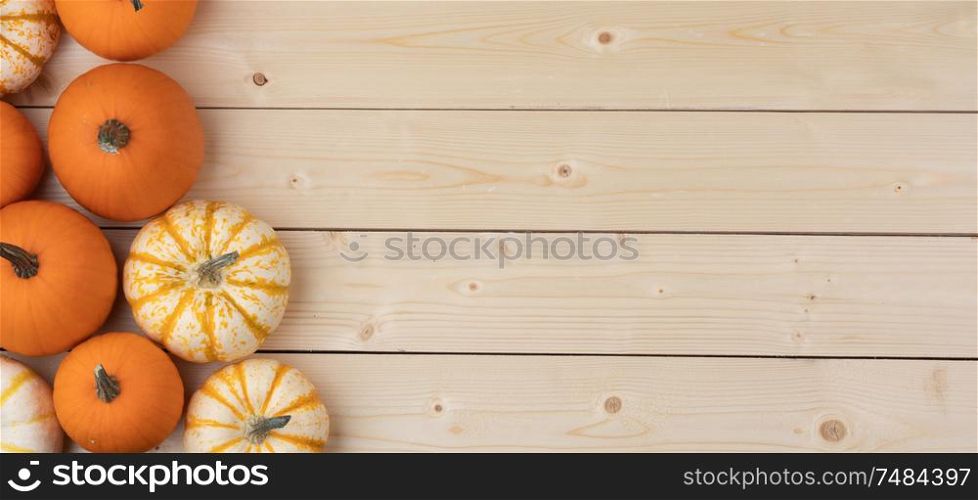 Many orange pumpkins on wooden background , Halloween concept , top view with copy space. Pumpkins on wooden background