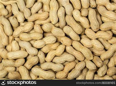 Many peanuts in shells, one upon the other background