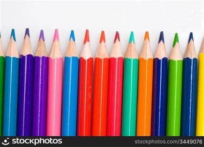Many pencils of different colors on a over white background