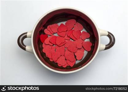 Many red hearts on the bottom of the soup tureen on white background.. Many red hearts on the bottom of the tureen.