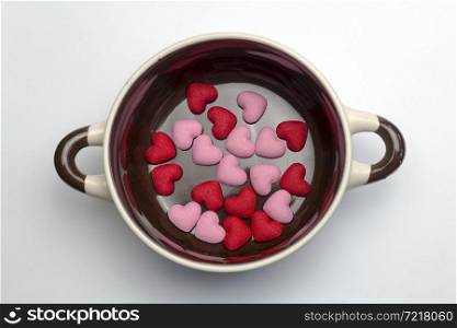Many red hearts on the bottom of the soup tureen on white background.. Many red hearts on the bottom of the tureen.