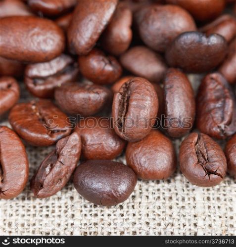 many roasted coffee beans on textile close up