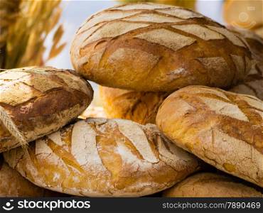 many rustic baked traditional rye bread loaves on a market stall outdoor