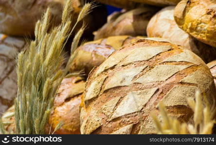 many rustic baked traditional rye bread loaves on a market stall outdoor