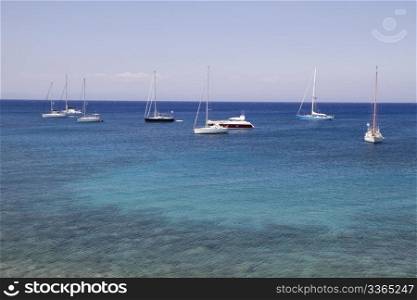Many sailing boats on clam ocean and blue sky