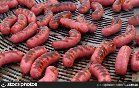 Many sausages cooking on a barbecue