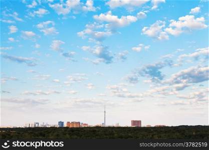 many small white clouds in blue sky over city in summer evening