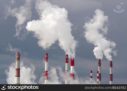 Many smoking chimneys against the sky