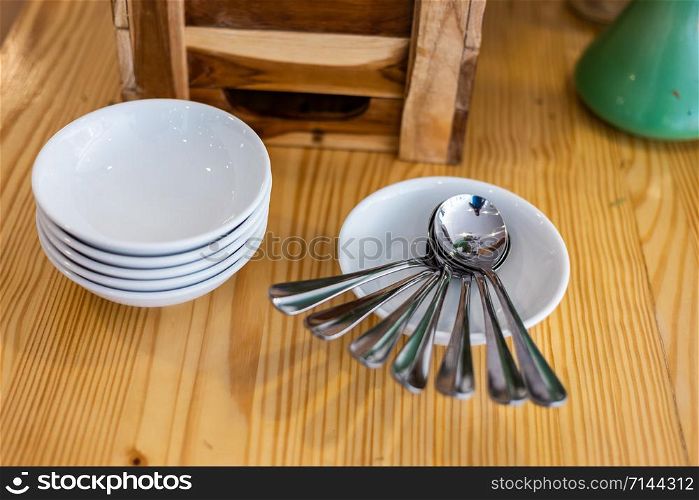 Many spoons and placed with many dishes on the dining table decoration in hotel.