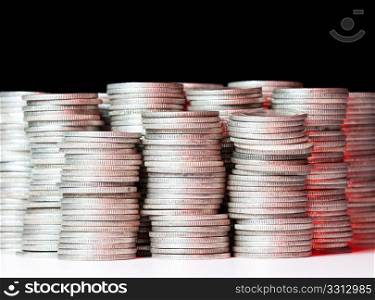 Many stacks of old silver dimes face on to camera and illuminated with red light