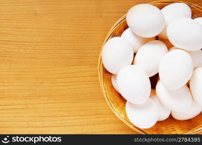 Many white eggs on the wooden table