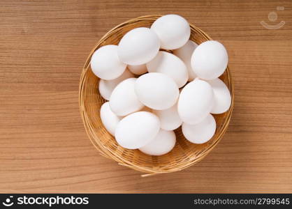 Many white eggs on the wooden table