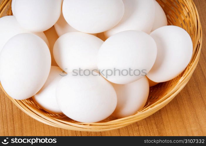 Many white eggs on the wooden table