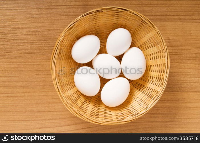 Many white eggs on the wooden table