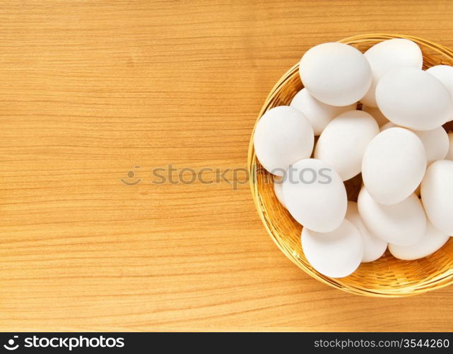 Many white eggs on the wooden table