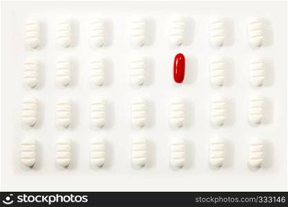 many white pills a red one on white background