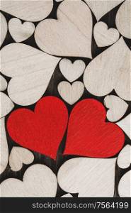 Many wooden colorless hearts background, two red special ones true love concept. Wooden hearts background
