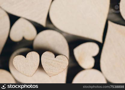 Many wooden colorless hearts background. Wooden hearts background