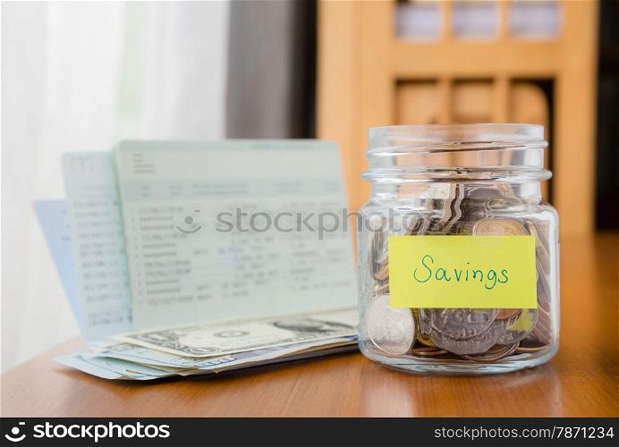 Many world coins in money jar with savings label on jar, concept to financial planning
