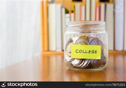 Many world coins in saving money jar with college label on jar, concept to financial planning for kids