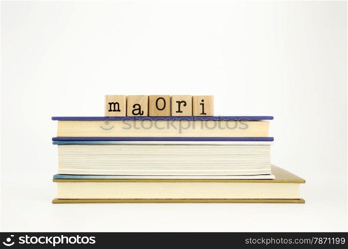 maori word on wood stamps stack on books, academic and language concept