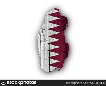 Map and flag of Qatar on weathered wood