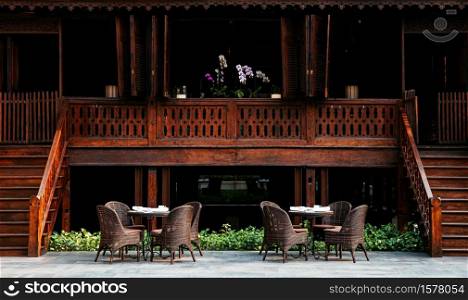 MAR 5, 2012 Chiang Mai, Thailand - Classic rattan chairs and table outdoor dining furniture set in old Asian vintage house