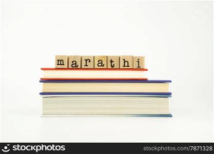 marathi word on wood stamps stack on books, foreign language and translation concept
