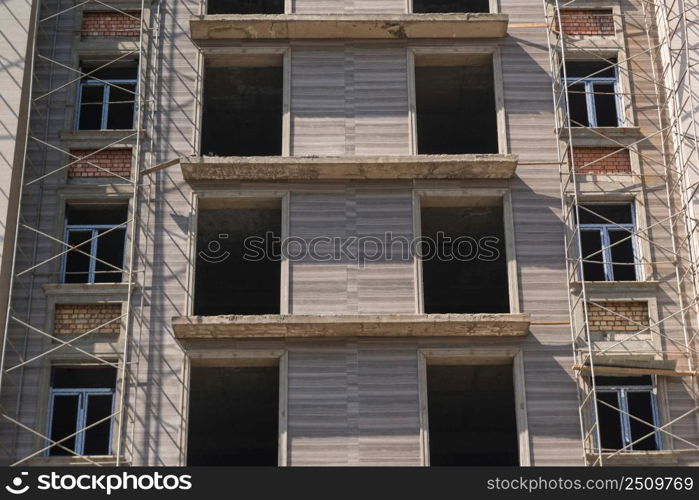 marble finishing works on the facade of a high building. scaffolding and supports