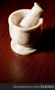 Marble mortar and pestle on dark wood background