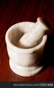 Marble mortar and pestle on dark wood background