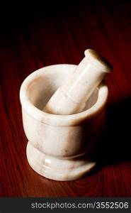 Marble mortar and pestle on dark wood background