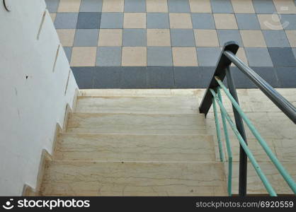 Marble staircase steps iron handrail and tiled floor abstract architectural detail.
