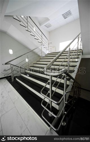 Marble staircase with a steel handrail in a modern building
