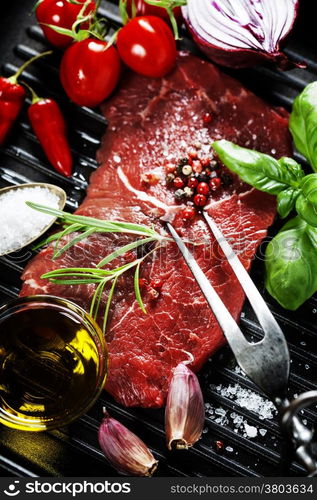 Marbled beef steak with meat fork and vegetables in a grill pan