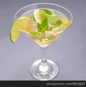 Margarita cocktail in a glass with cut lime. Classic lime margarita cocktail
