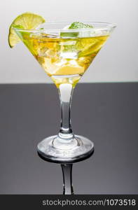 Margarita cocktail in a glass with cut lime. Classic lime margarita cocktail