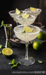 Margarita cocktail with lime and ice on dark wooden table with copy space. Classic Margarita and Daiquiri Cocktail.. Margarita cocktail with lime