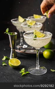 Margarita cocktail with lime and ice on dark wooden table with copy space. Classic Margarita and Daiquiri Cocktail.. Margarita cocktail with lime