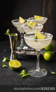 Margarita cocktail with lime and ice on dark wooden table with copy space. Classic Margarita and Daiquiri Cocktail.. Margarita cocktail with lime