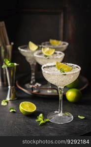 Margarita cocktail with lime and ice on dark wooden table with copy space. Classic Margarita and Daiquiri Cocktail.. Margarita cocktail with lime